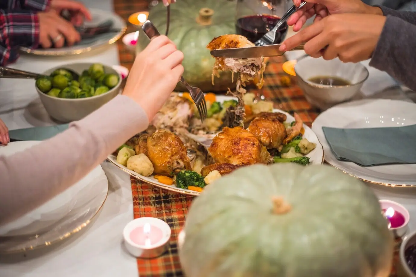 Hände, die mit Gabeln Fleisch nehmen