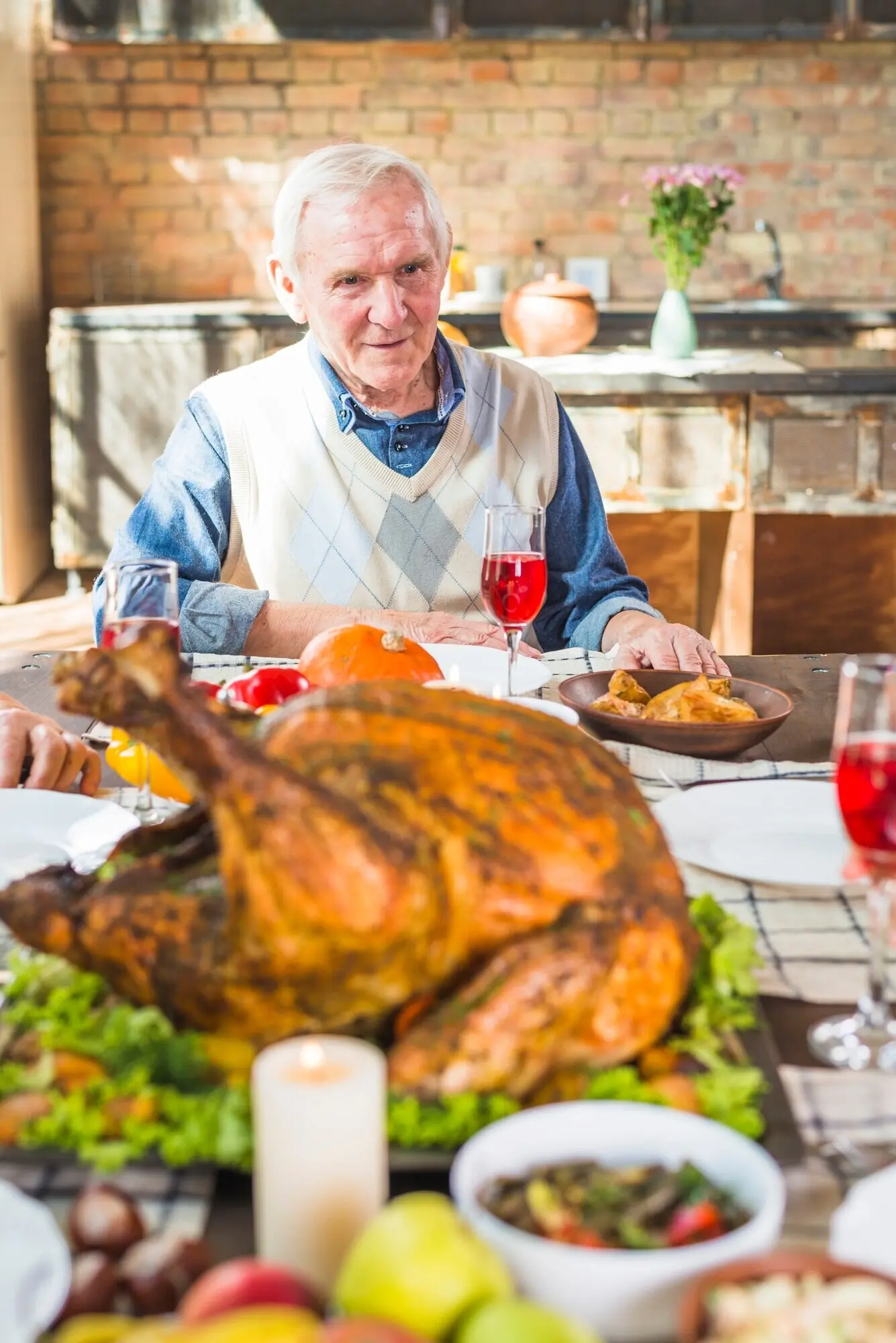 Ein älterer Mann sitzt an einem Tisch mit Essen.